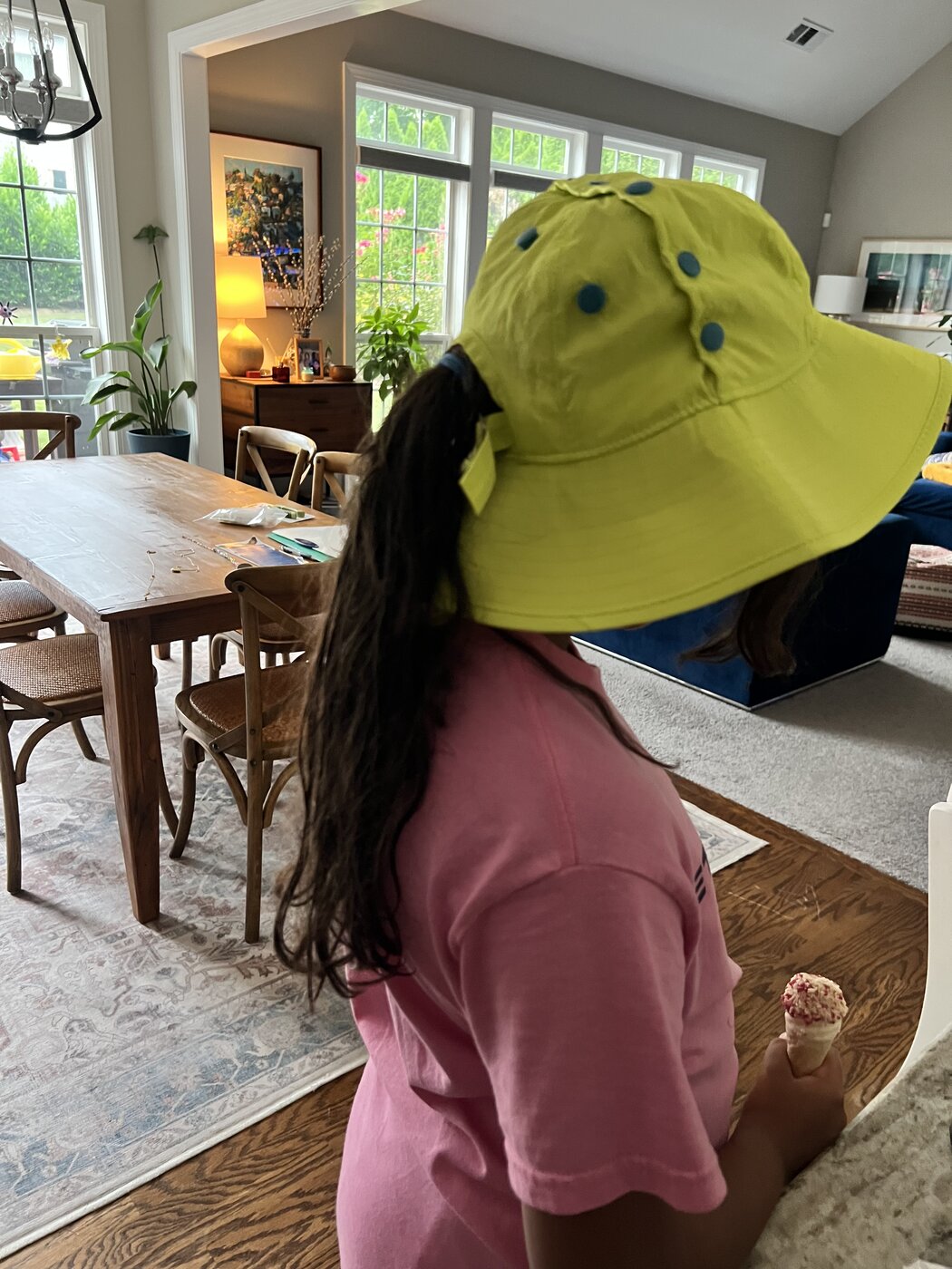 A long ponytail flowing through the back opening of the yellow hat